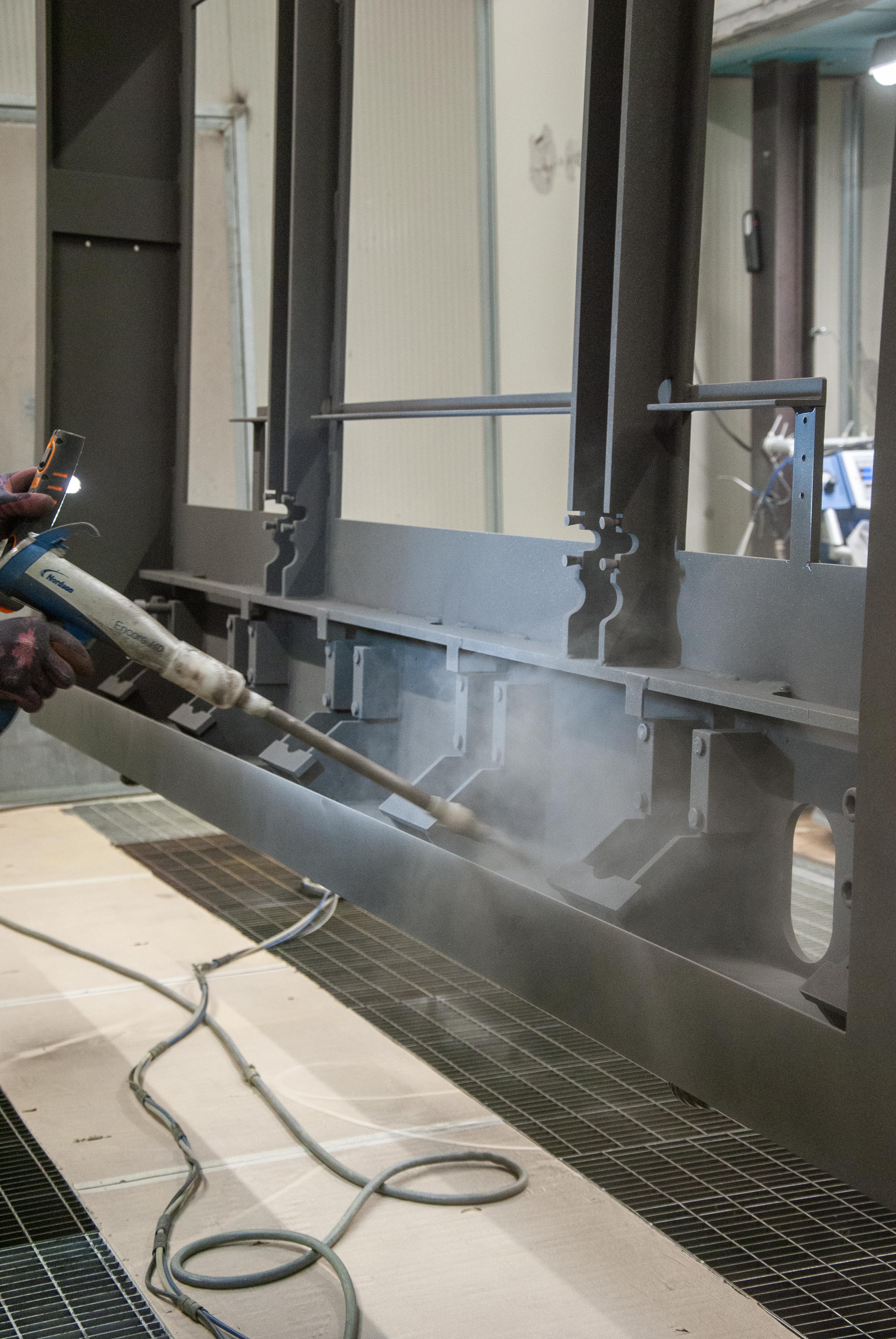 Picture of a man coating the steel frame of a road blocker