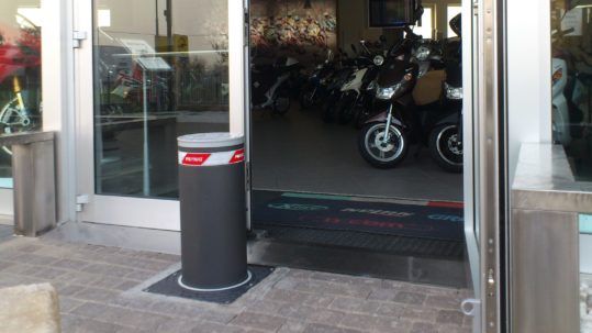 Image of an automatic bollard installed in front of a shop's window for protection