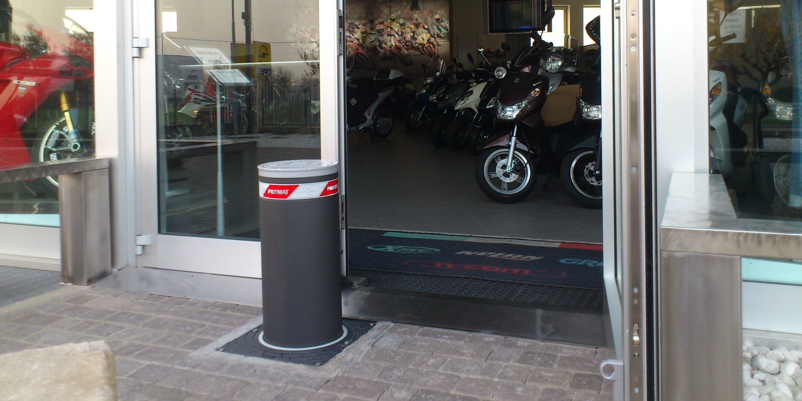 Image of an automatic bollard installed in front of a shop's window for protection